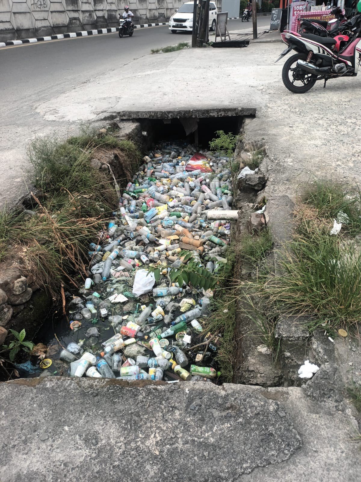 Drainase Tersumbat Sampah di Bawah JMP, Ancaman Banjir di Jalan Sudirman Dibiarkan